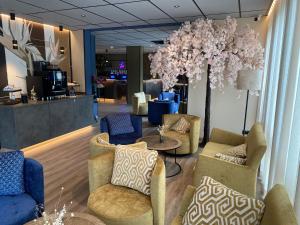 a lobby with chairs and a table and flowers at Thermalhotel Kemper in Erwitte