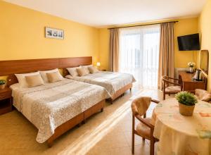 a hotel room with two beds and a table at Willa Julia in Rewal