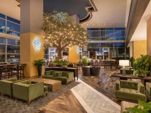 a lobby of a hotel with green chairs and tables at Fairmont Austin in Austin