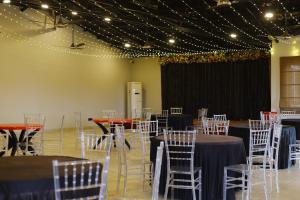 a banquet hall with tables and chairs and lights at Velora The Luxury Resort in Māndu
