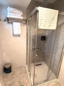 a shower stall in a bathroom with towels at Bloom Hotel in Baghdād +35 photos