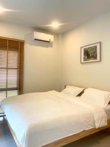 a bedroom with a large white bed and a window at Moon & Banana in Ko Phangan +12 photos