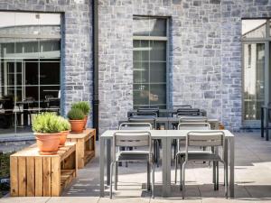 a row of tables and chairs in front of a brick building at Mercure Han-sur-Lesse in Han-sur-Lesse