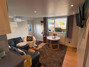 a living room with a couch and a table at The Travellers Retreat in Neston