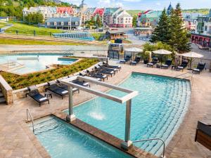 a view of two pools with chairs and tables at Fairmont Tremblant in Mont-Tremblant