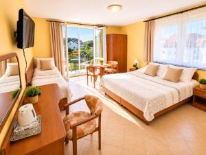 a bedroom with two beds and a television and a table at Willa Julia in Rewal