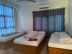 two twin beds in a room with a window at Hotel Everest in Butwāl