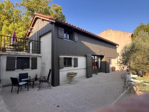 a black and white house with a balcony and chairs at Le CRAMPOT in Lectoure
