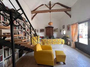 a living room with a yellow chair and a couch at Le CRAMPOT in Lectoure