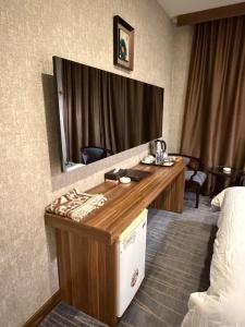 a hotel room with a vanity with a mirror at Bloom Hotel in Baghdād