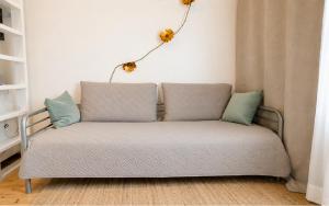 a couch in a living room with a lamp on the wall at Alppila Lodge Studio in Helsinki