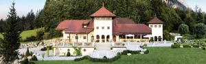 a large building with a red roof in a field at Ansitz Wartenfels in Thalgau