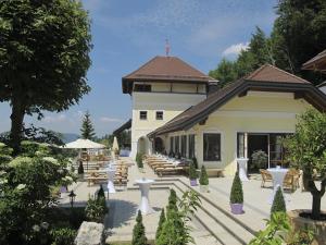a building with tables and chairs in front of it at Ansitz Wartenfels in Thalgau