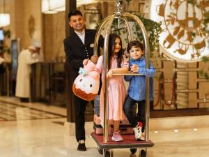 a man and two children riding on a roller coaster at Swissotel Makkah in Mecca