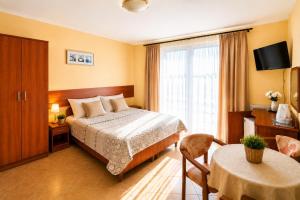 a hotel room with a bed and a table at Willa Julia in Rewal