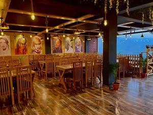 a dining room with wooden tables and chairs at The Pine Woods - A Four Star Luxury Resort In Mussoorie Near JW Marriott in Mussoorie