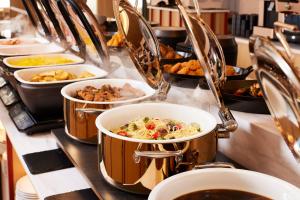 a buffet line with pots and pans of food at HOTEL MYSTAYS Nagoya Sakae -Renewed in September 2026 All Guest Rooms & Breakfast in Nagoya