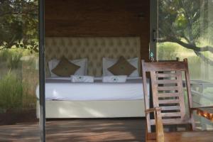 a bedroom with a bed and a wooden chair at Wilpattu Wilderness Camping in Wilpattu
