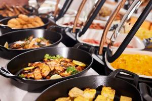 a row of pans filled with food on a table at HOTEL MYSTAYS Nagoya Sakae -Renewed in September 2026 All Guest Rooms & Breakfast in Nagoya