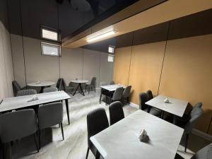 a dining room with tables and chairs in a room at Meridian Hotel in Georgīevka
