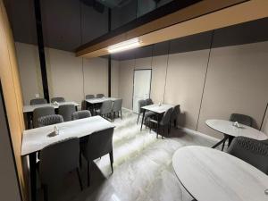 a dining room with tables and chairs and a chalkboard at Meridian Hotel in Georgīevka