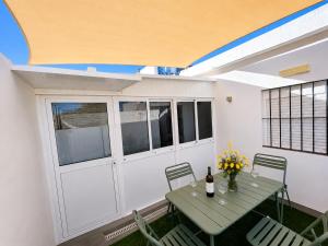 a patio with a table with flowers and a bottle of wine at La casa de curro in Arcos de la Frontera