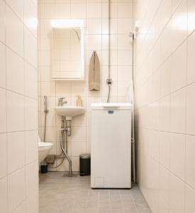 a white bathroom with a sink and a toilet at Alppila Lodge Studio in Helsinki