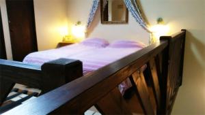 a bed in a bedroom with a wooden rail at Langford Apartment and Rooms in Bristol