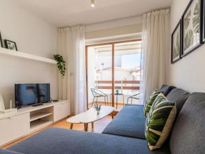 a living room with a blue couch and a tv at Renteando Albir Apartments in Albir