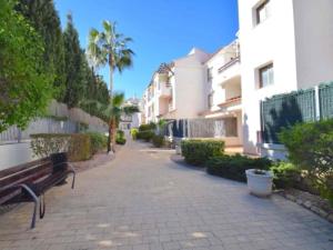 a bench on a sidewalk next to some buildings at Renteando Albir Apartments in Albir