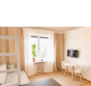 a room with a bed and a table and a window at Alppila Lodge Studio in Helsinki