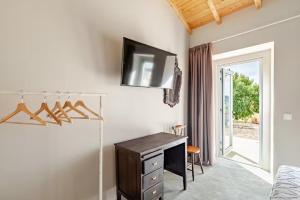 a bedroom with a desk and a television on the wall at Monte Garcia Nunes in Coruche