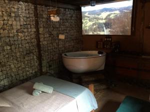 a bathroom with a tub and a sink and a window at Chalé Medieval in Brumadinho
