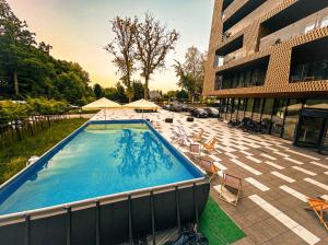 a large swimming pool next to a building at GRANO APARTHOTEL Ustronie Morskie in Ustronie Morskie