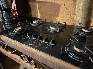 a stove top with four burners on top of it at Chalé Medieval in Brumadinho