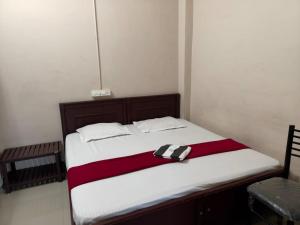 a bedroom with a bed with a black and white blanket at Misty Square Residency in Kalpetta