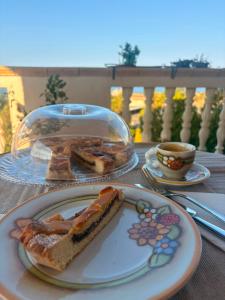 a table with a plate with a piece of cake and a cup of coffee at L'Incanto del mare GC in Saline Joniche