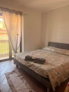 a bedroom with a bed and a window at L'Incanto del mare GC in Saline Joniche