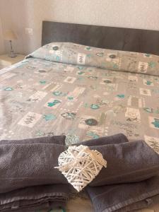 a bed with a comforter and towels on it at L'Incanto del mare GC in Saline Joniche +1 photo