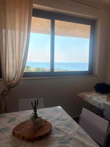 a dining room with a table with a large window at L'Incanto del mare GC in Saline Joniche