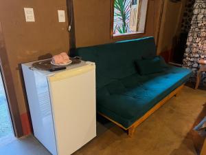 a green couch sitting on top of a refrigerator at Chalé Medieval in Brumadinho +16 photos