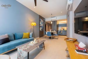 a living room with a blue couch and a table at Assana Cenang Beachview oakville by sync in Pantai Cenang