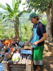 a man preparing food on a picnic table at Cindrella Sky Nest Camp Ella in Ella