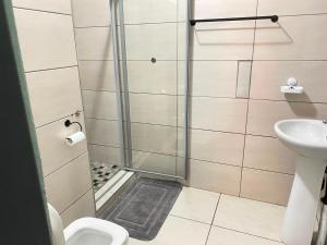 a bathroom with a shower and a toilet and a sink at Stay Arcadia Guest House in Pretoria +65 photos