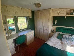 a bedroom with a bed and a desk and a window at DanowskieCamp in Danowskie