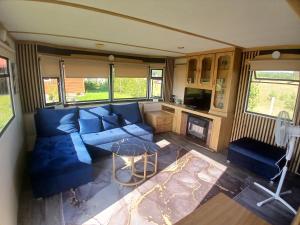 a living room with a blue couch and a table at DanowskieCamp in Danowskie