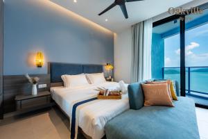 a bedroom with a large bed and a couch at Assana Cenang Beachview oakville by sync in Pantai Cenang +120 photos
