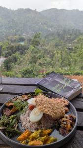 a plate of food on a table with a book at Cindrella Sky Nest Camp Ella in Ella +35 photos
