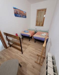 a small room with two beds and a chair at ALBACHIARA in Ramazzano