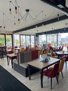 a restaurant with tables and chairs and windows at Kopaonik Mountain Retreat in Cajetina
